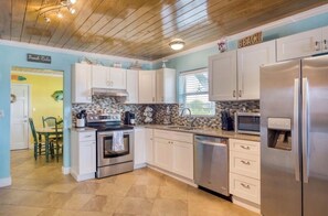 A kitchen with white cabinets, stainless steel appliances, and a tiled backsplash. - Charming St. Augustine Retreat Near Butler Beach with AC (St. Augustine)