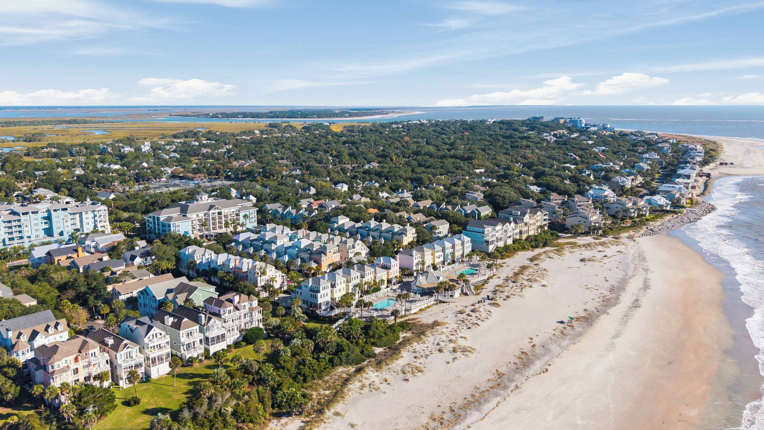 Ein Küstenwohngebiet mit Häusern direkt am Strand, einem großen Hotel und dem Strand.
