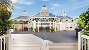 Ein Restaurant direkt am Strand mit einer überdachten Terrasse, Kübelpflanzen und freiem Blick auf das Meer.