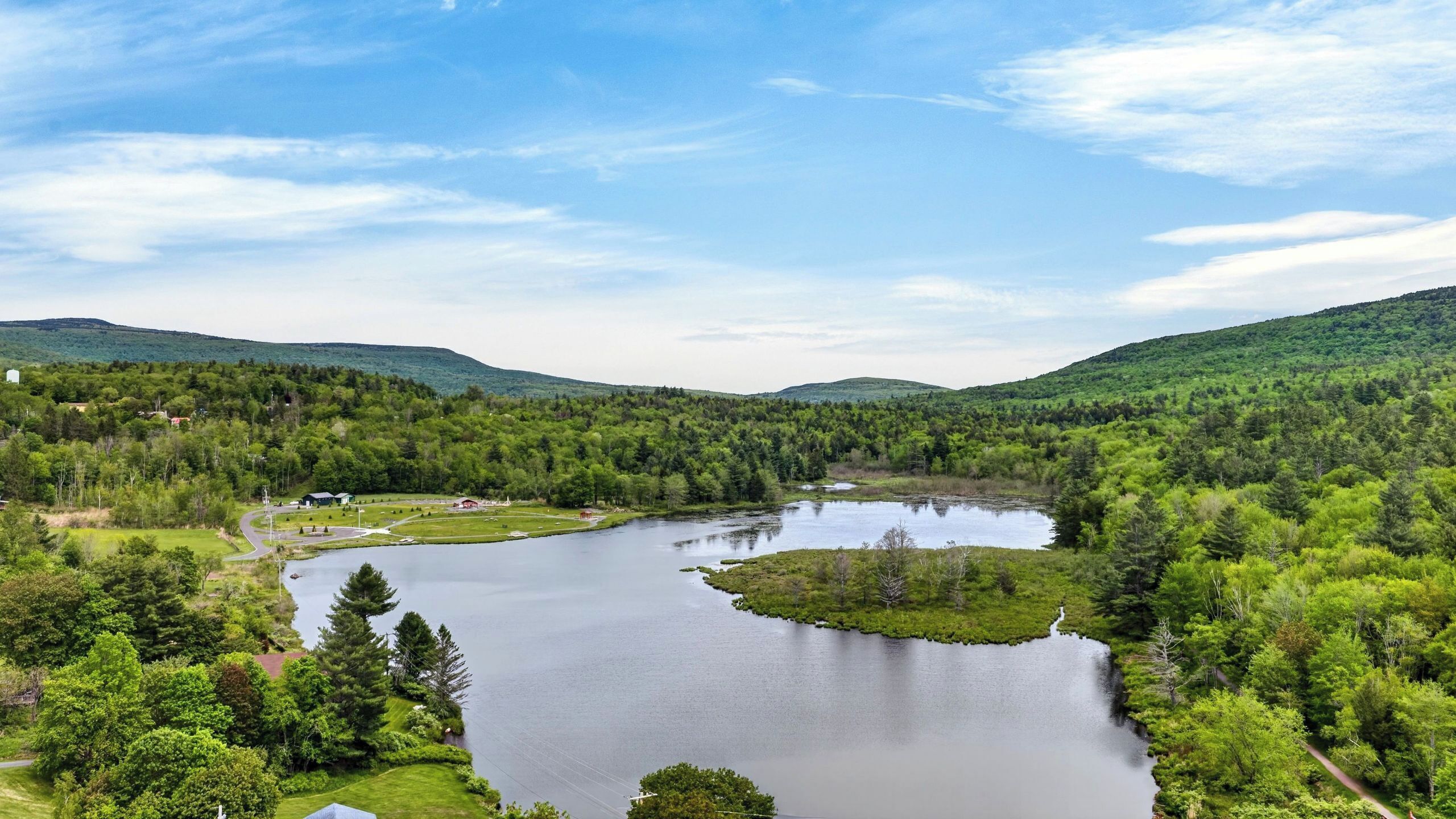 A lake surrounded by dense forest and hills.