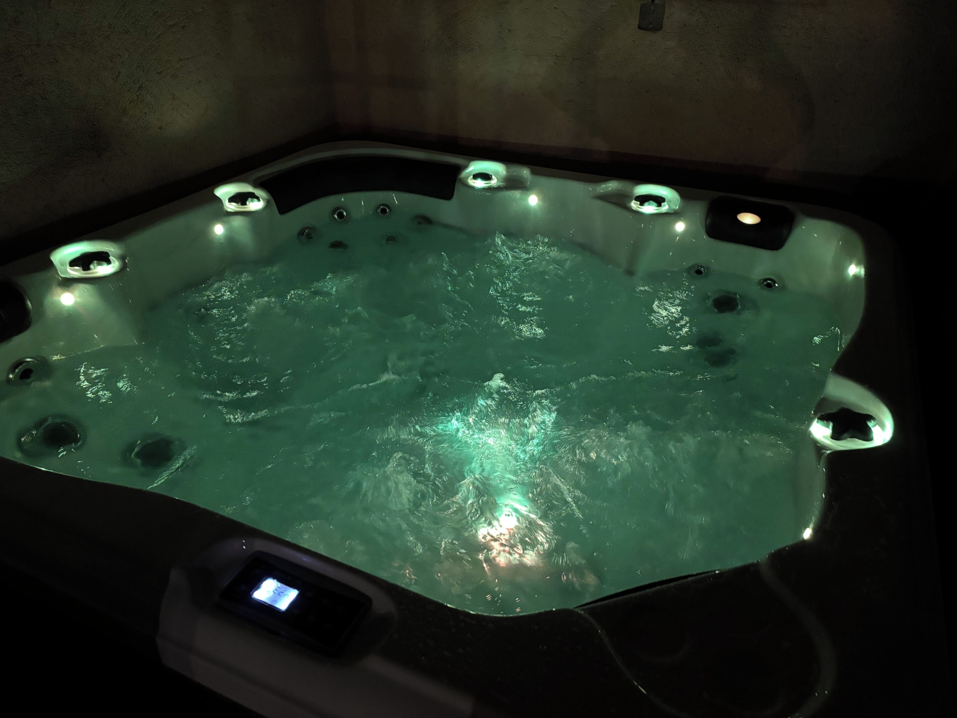 A hot tub with a control panel and multiple jets.