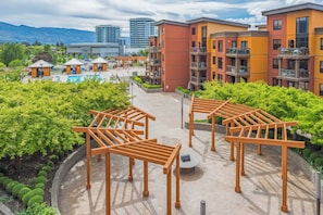 Un hotel con varios pisos, zonas de estar al aire libre y una piscina.