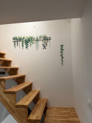 A wooden staircase with a wall-mounted plant display.