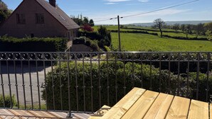 A house with a brick exterior, a metal fence, and a view of a green field. - Holiday Home “Gîte Des 3M” with Private Terrace (Leubringhen)
