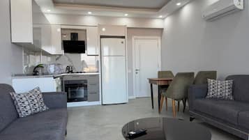 A modern living space with a kitchen, dining area, and seating.