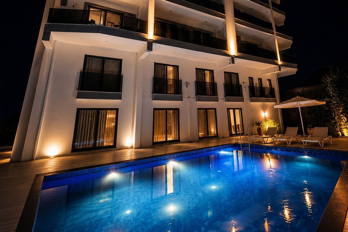 Hotel com vários andares, piscina e área de estar ao ar livre.