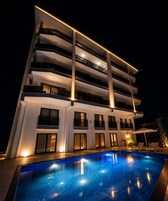 Un hotel de varios pisos con piscina y zona de estar al aire libre.
