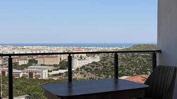 Ein Balkon mit Blick auf eine Stadtlandschaft und das Meer.