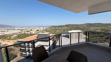 Un balcón con vistas a un paisaje urbano y montañas.