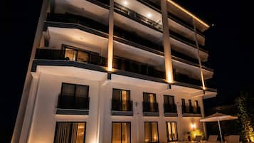 A multi-story hotel with a swimming pool and outdoor seating.