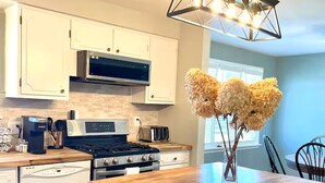 Una cocina moderna con armarios blancos, una isla central, una estufa y un microondas.