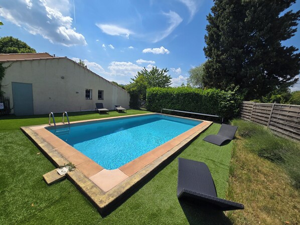 A rectangular swimming pool with a metal ladder, surrounded by artificial grass and a wooden fence. - Provencal house with private pool (Salernes)