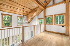Ein Holzinterieur mit großen Fenstern, einer weißen Brüstung und einem Holzboden.