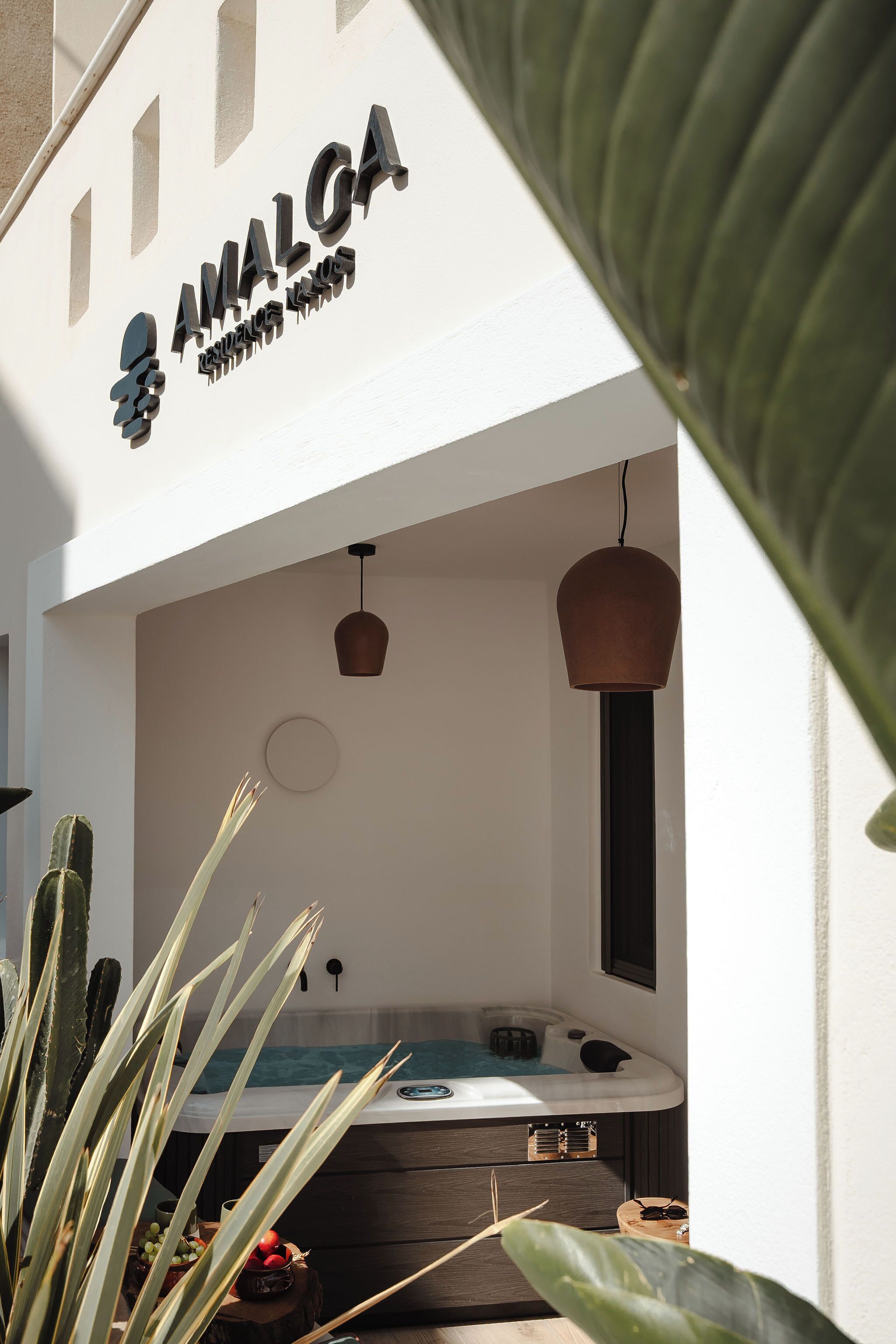Un espace bien-être comprenant un jacuzzi, un luminaire au plafond et une enseigne portant l’inscription « AMALGA ».