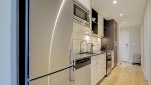A modern kitchen with stainless steel appliances, a microwave, and a built-in oven. - Serene and Calming Downtown Suite (Victoria)