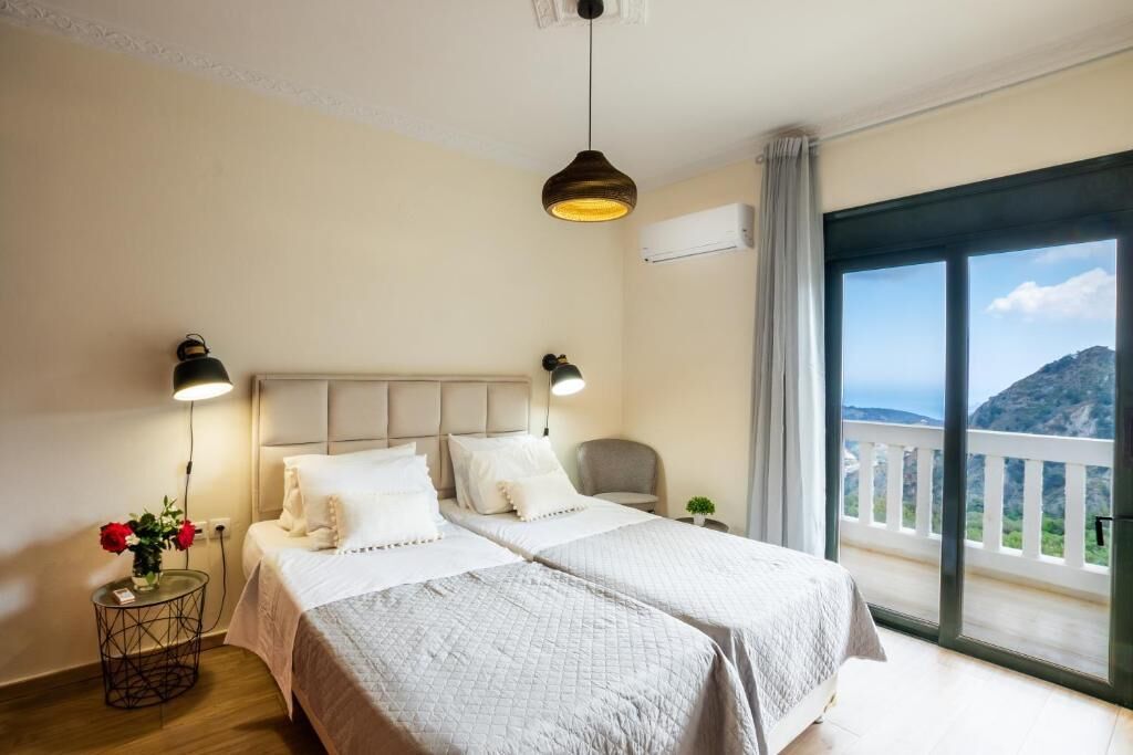 Een hotelkamer met twee bedden, een balkon en een modern design, met uitzicht.