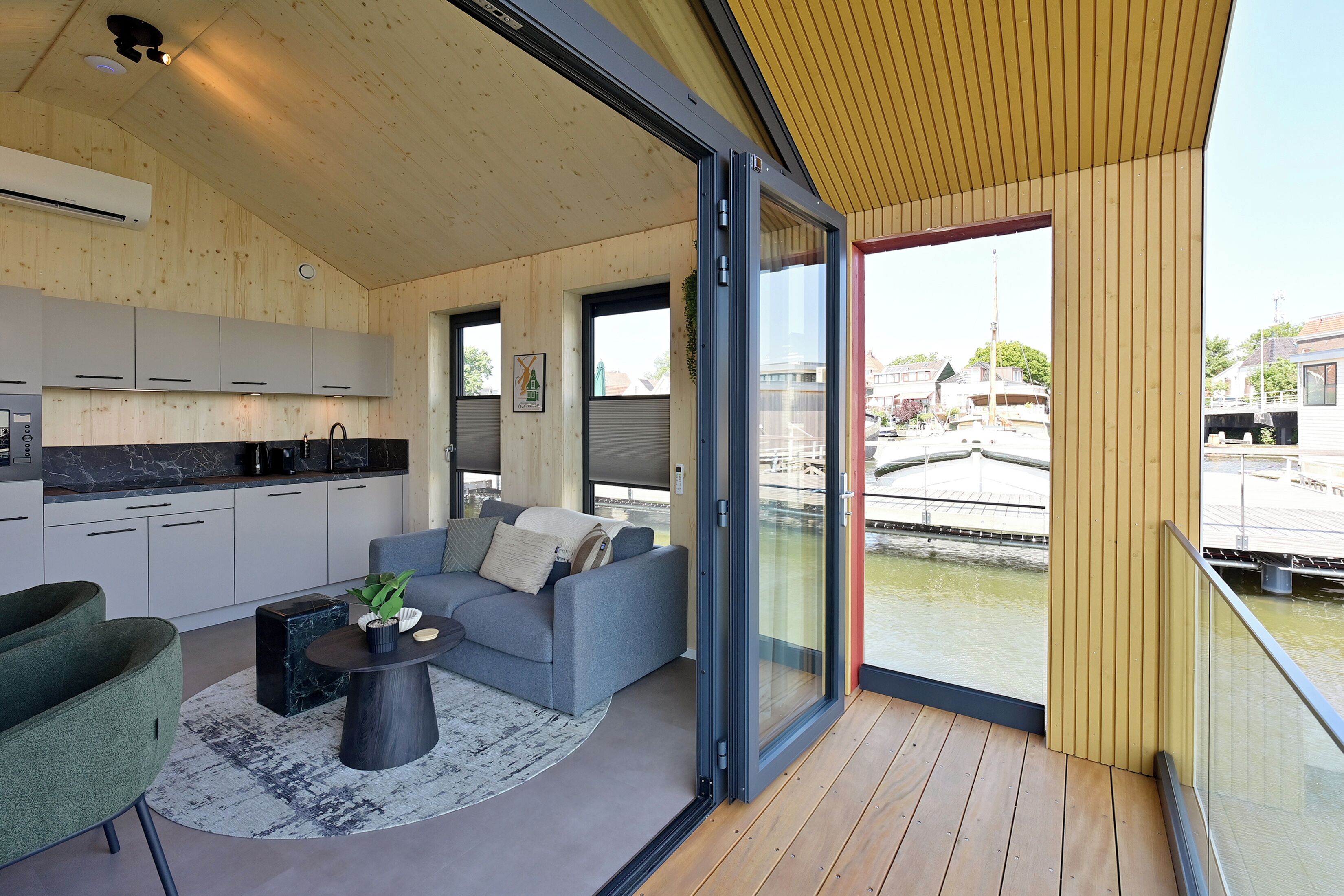 Un interior moderno con cocina, zona de estar y vistas a un canal.