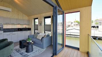 Un interior moderno con cocina, zona de estar y vistas a un canal.