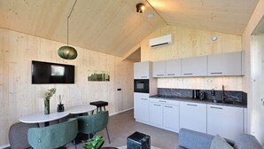 A modern kitchen with white cabinets, a built-in microwave, and a black countertop.