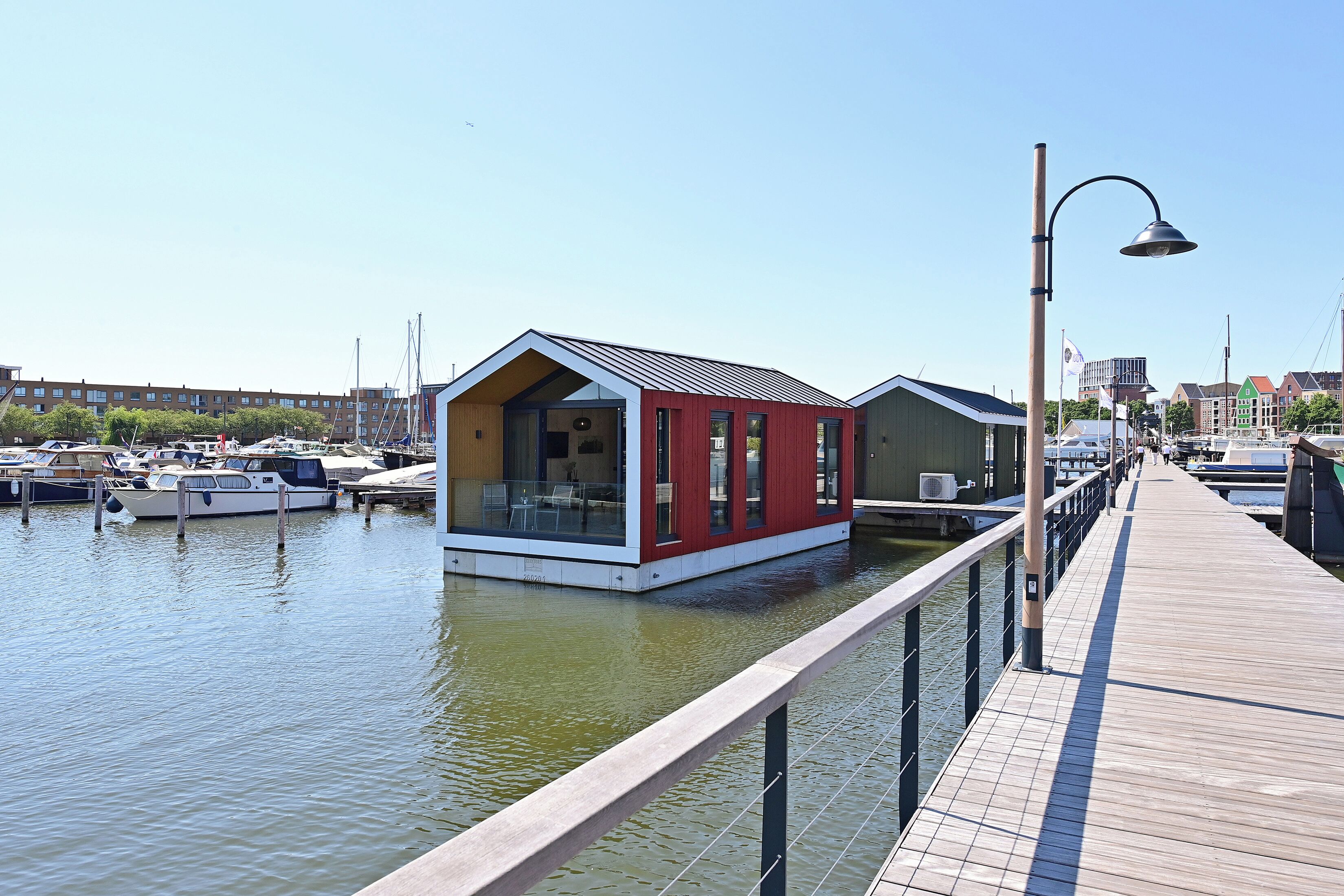 A waterfront property with a dock, a red building, and a green building.