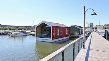 A waterfront property with a dock, a red building, and a green building.