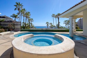 A pool with a hot tub, palm trees, and a view of the ocean. - Casa 4 C s in Cabo San Lucas (San José del Cabo)