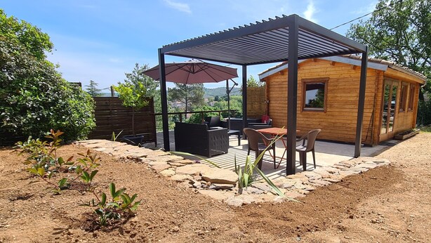 A wooden cabin with a patio, outdoor seating, and a pergola. - Charming wooden chalet - Ardèche (Joyeuse)