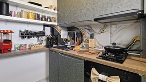 A modern kitchen with a built-in stove, a coffee maker, and various kitchen utensils. - Nova City View+ Near Hospital+Full Kitchen+A/C+Free Public Parking (Bucharest)