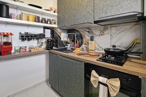 Eine moderne Küche mit Einbauherd, Kaffeemaschine und verschiedenen Küchenutensilien.
