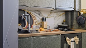 A modern kitchen with a marble backsplash, a gas stove, and a built-in oven. - Nova City View+ Near Hospital+Full Kitchen+A/C+Free Public Parking (Bucharest)
