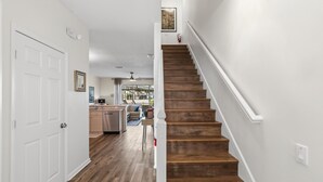 A staircase with wooden steps and white railings, leading to a room with a white door and a ceiling fan. - Gorgeous 3/3 townhome at gated Resort Community at Windsor Palms!! (Kissimmee)