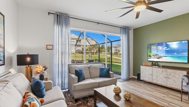 A modern living room with a sofa, coffee table, and TV. - Gorgeous 3/3 townhome at gated Resort Community at Windsor Palms!! (Kissimmee)
