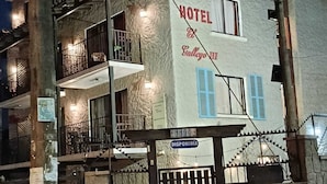 Kaksikerroksinen rakennus, jonka yläpuolella on kyltti, jossa lukee ”HOTEL El Colegio III”, ja portissa on teksti ”DISPONIBLE”.