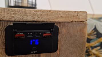 Ein Holz-Lautsprecher mit digitaler Anzeige, einem Vogelkäfig und einer Steckdose.