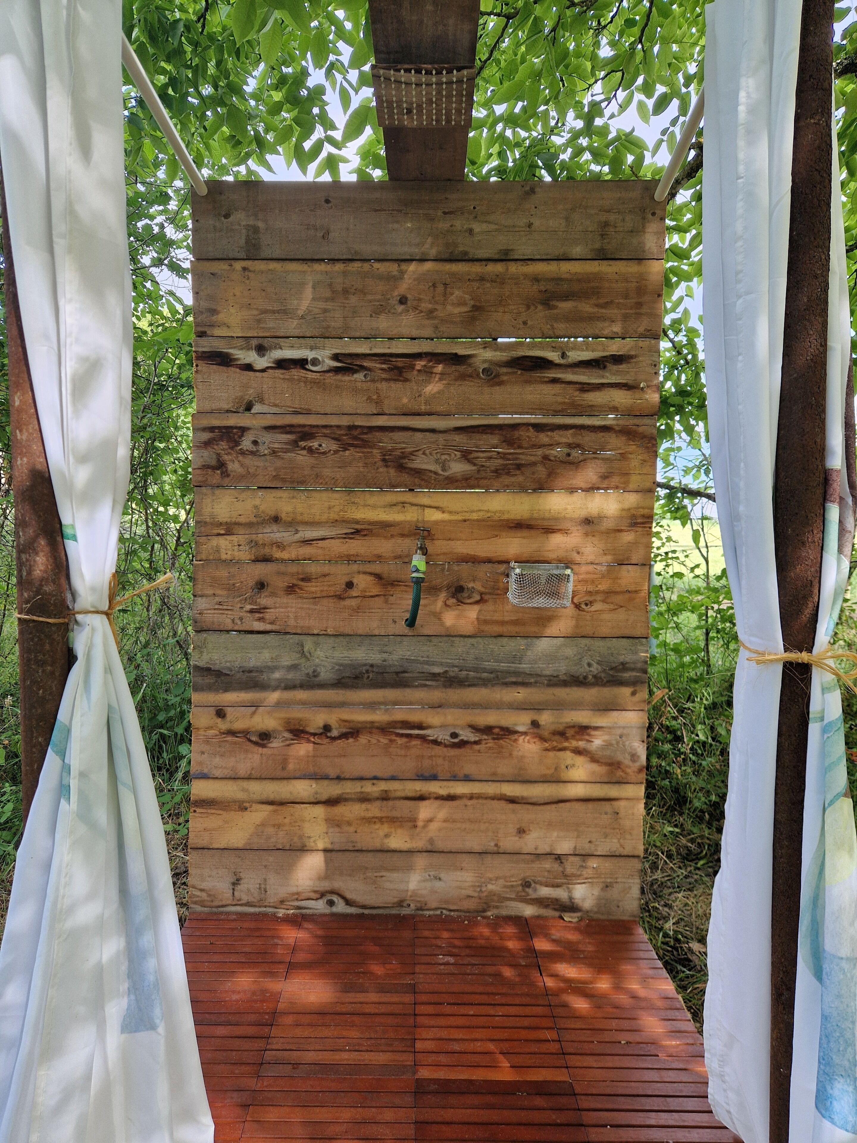 A wooden structure with a hanging net and a metal hook.