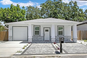 Ein Bungalow mit Garage, Eingangstür und Briefkasten.