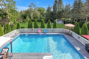 A rectangular swimming pool with a wooden deck and white railing. - 3-bedroom house in Jamesport with pool (Jamesport)
