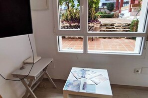 Ein Zimmer mit Fenster, Schreibtisch und Tisch mit Broschüren.