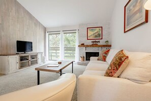 A living room with a fireplace, a television, and a sofa. - Cozy Condo Ranch at Roaring Fork (Carbondale)