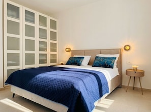 A bedroom with a bed, two bedside lamps, a nightstand, and a wardrobe with frosted glass doors. - Mediterranean Dream Villa With Pool (Rogoznica)