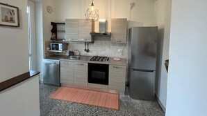 Una cucina moderna con piano cottura a gas, elettrodomestici in acciaio inossidabile e mobili in legno chiaro.