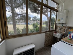 A bathroom with a large window, a radiator, a sink, and a water heater. - Tourist Accommodation in Trincere Street free parking (Pisa)