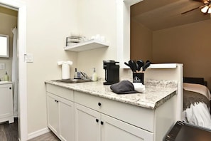 A compact kitchen with a granite countertop, a coffee maker, and a knife block. - Studio Apt #3 in Historic Downtown Winter Garden, across from the Bike Trail (Winter Garden)