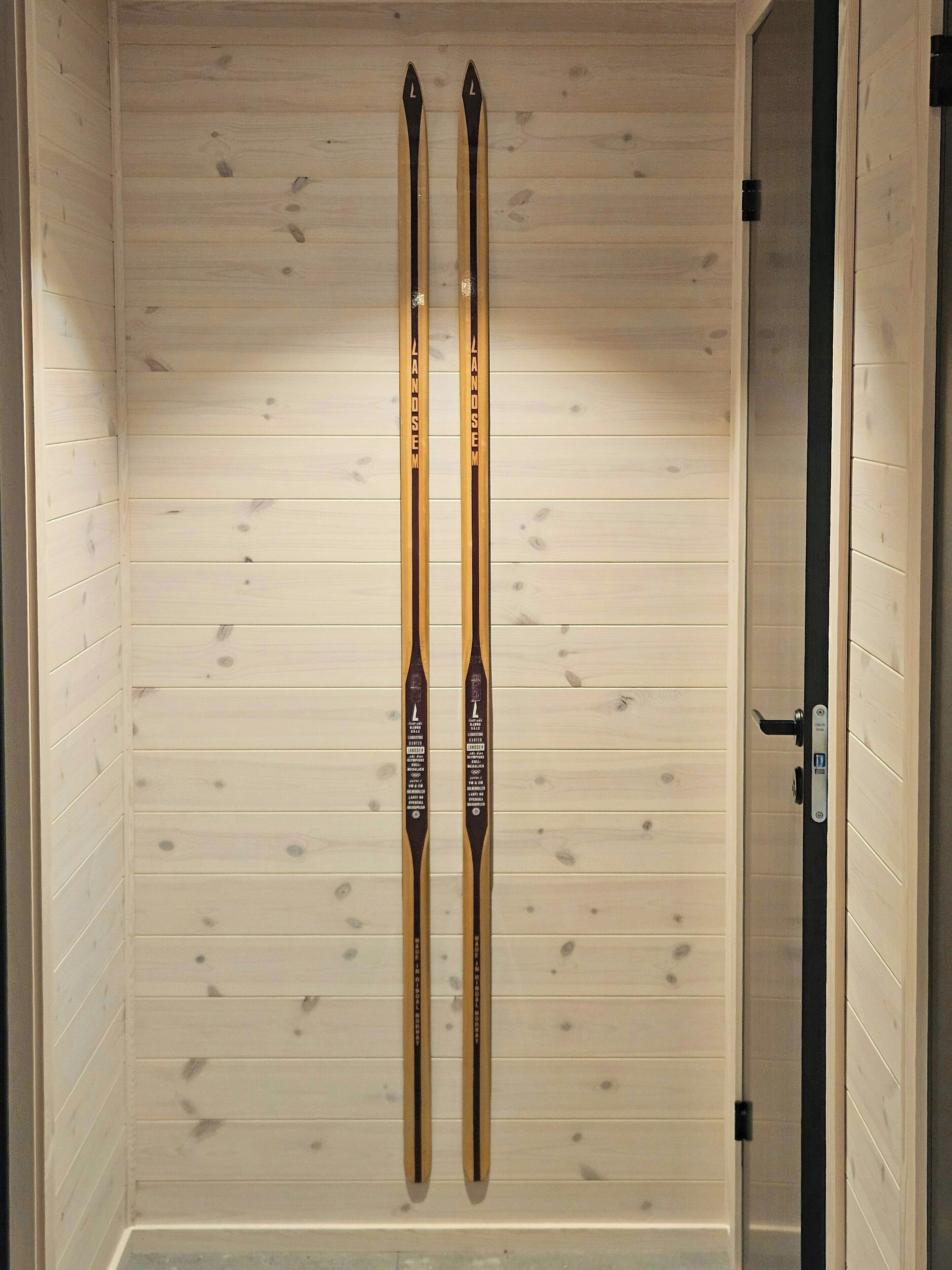 Une pièce en bois, avec deux paires de skis appuyées contre le mur.