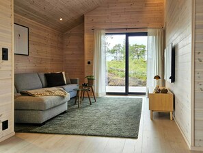 A cozy room with a sofa, a small table, and a view through a glass door.