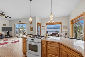 A spacious kitchen with a large island, a gas stove, and a view of the outdoors.