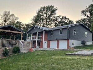 A two-story house with a covered porch, a garage, and a well-maintained lawn.