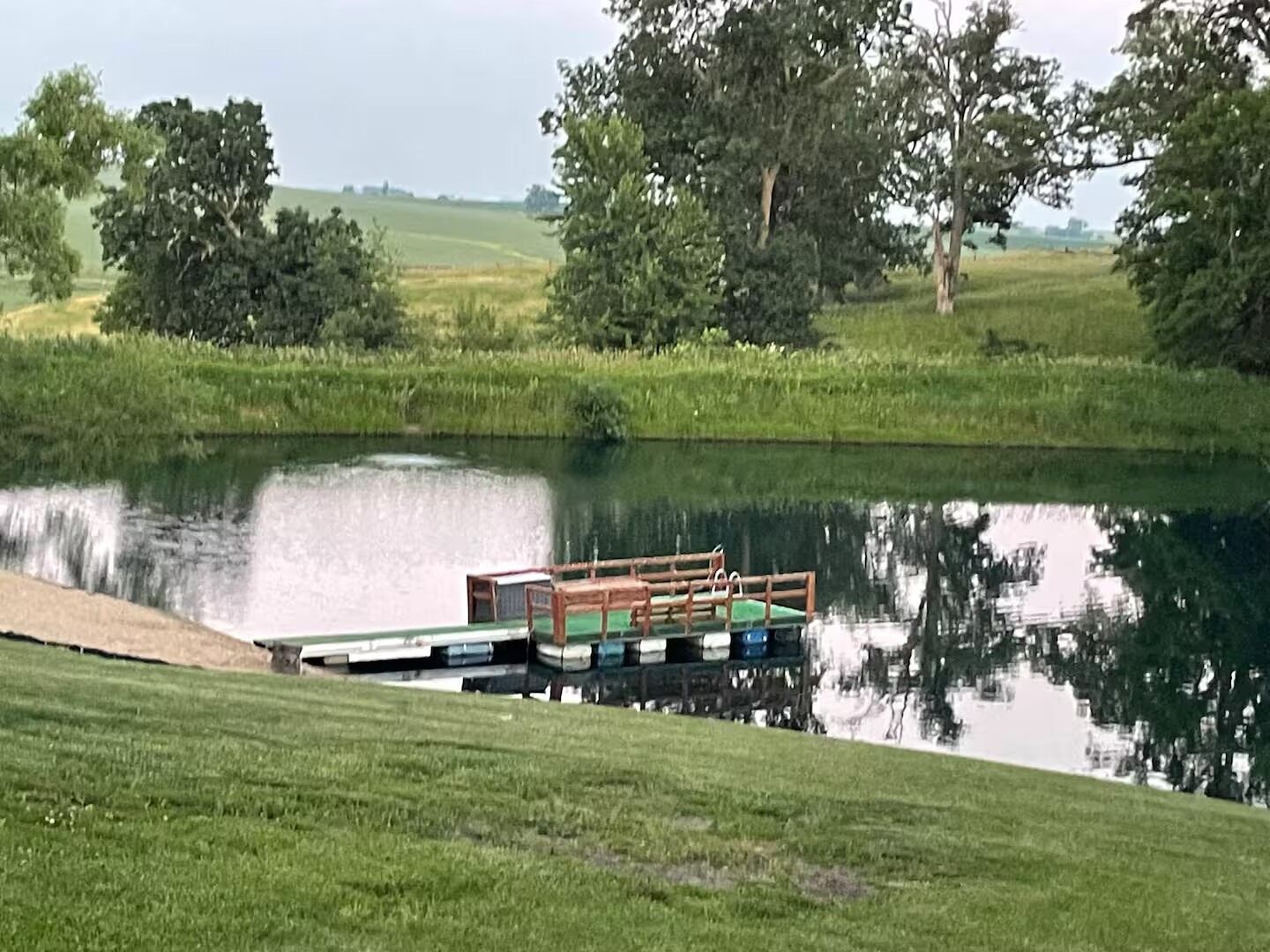 A calm river with a dock and a small boat.