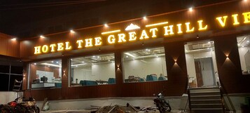 A hotel exterior with a prominent sign reading 'HOTEL THE GREAT HILL VIBE.'