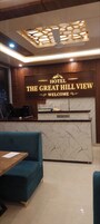 A reception area with a sign for 'Hotel The Great Hill View' and a reception desk.